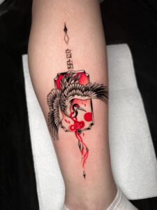 Neo-Japanese crane tattoo with red accents and decorative frame by Tizio Art in Antwerp
