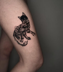 Tattoo of a cloaked wolf with abstract pattern and full black areas – Tizio Art